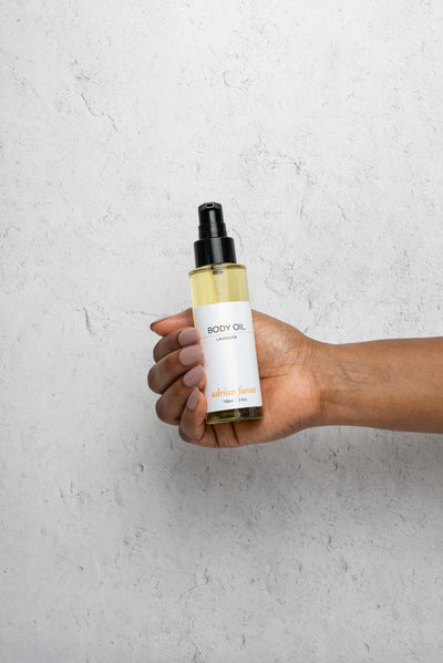 Lavender body oil being held in hands to show scale